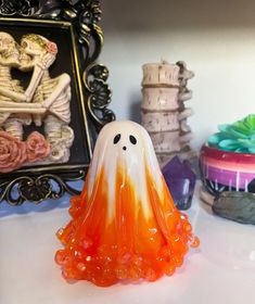 an orange and white candy ghost sitting on top of a table next to other decorations