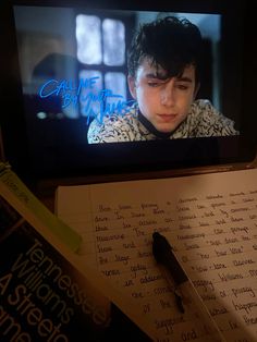 an open laptop computer sitting on top of a desk next to a note pad and pen