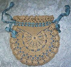 an old crocheted purse with blue ribbon on the bottom and lace around it