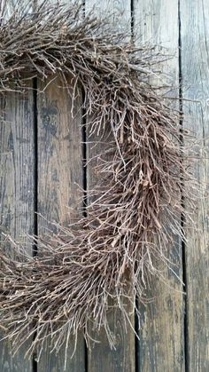 a wreath made out of branches on top of a wooden floor