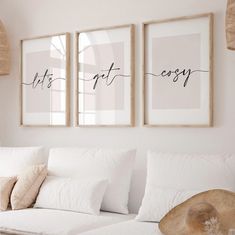 two framed art prints hanging on the wall above a white couch in a living room