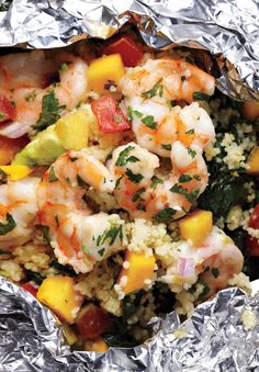 shrimp and rice in foil with vegetables on the side, ready to be eaten for lunch