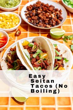 three tacos sitting on top of a white plate next to bowls of beans, corn and guacamole