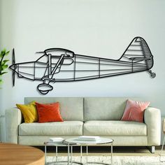 a living room with a white couch and a wall mounted air plane on the wall