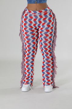 a woman wearing red, white and blue patterned pants with fringes on the legs