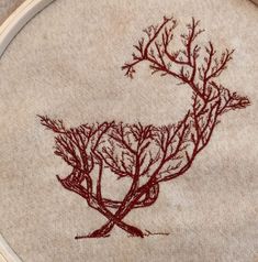 a close up of a embroidery on a piece of cloth with trees in the background