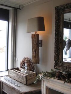 a living room filled with furniture and a lamp on top of a wooden table next to a window