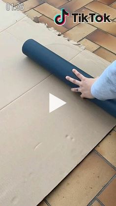 a person rolling up a yoga mat on the ground