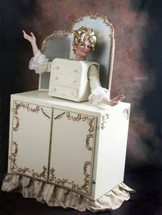 a woman is sitting on top of a dresser