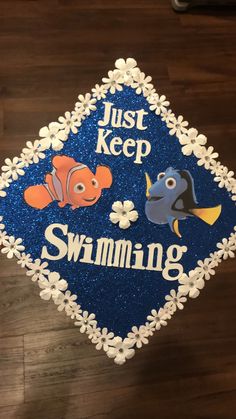 a decorated graduation cap that says just keep swimming