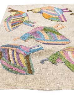 the rug has colorful birds on it and is made out of jute material with multicolored stripes