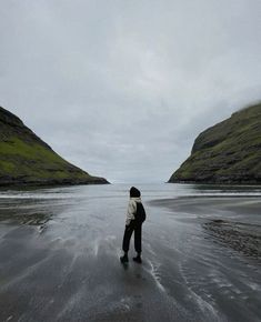 a man standing on top of a wet beach