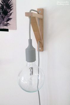 a light bulb is plugged into the wall with a wooden holder on one side