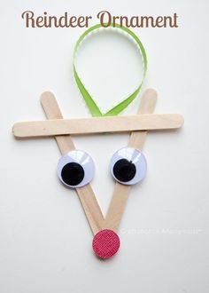 a craft made out of pops sticks with eyes and a green headband on it