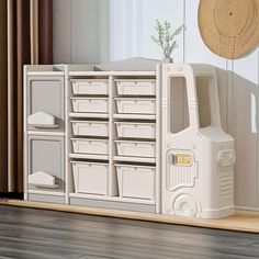 a white toy truck sitting on top of a hard wood floor next to a window