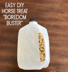 a plastic bottle filled with dog treats sitting on top of a wooden table next to a sign that says, easy diy horse treat boredom buster