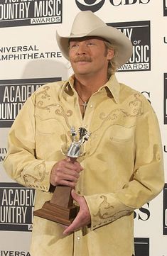 a man with a cowboy hat holding an award