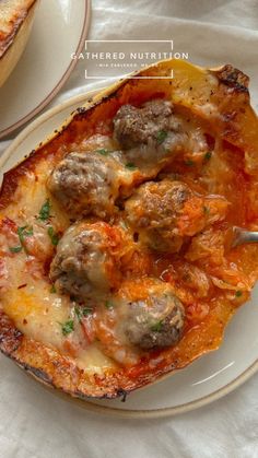 a white plate topped with meatballs covered in sauce and cheese on top of it