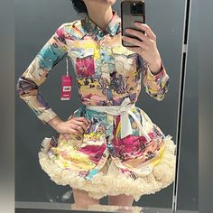 a woman taking a selfie in front of a mirror wearing a dress with flowers on it