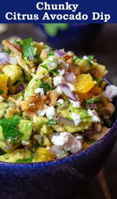 a blue bowl filled with salad and topped with feta cheese, avocado and cilantro