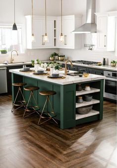 a kitchen with white cabinets and green island