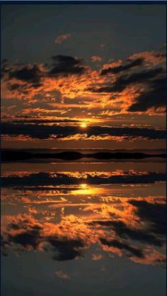 the sun is setting over water with clouds in the sky and reflecting on the water