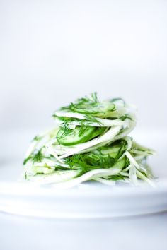 a white plate topped with cucumbers on top of a table