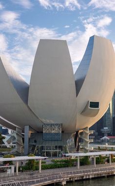 a large building with an unusual design on the side of it's face next to a body of water