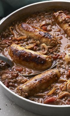 two sausages are being cooked in a large pot