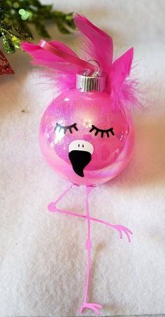 a pink christmas ornament with a bird on it's head and eyes