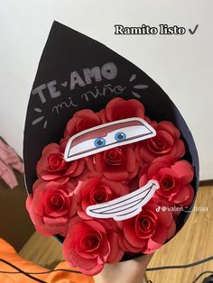 a person holding a bouquet of red roses in front of their face with the word team on it