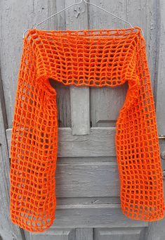 an orange scarf hanging on a wooden door