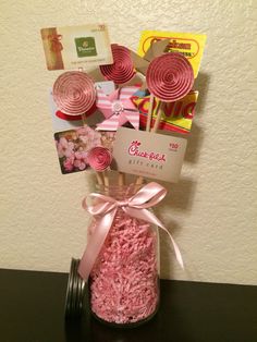 a jar filled with pink candies and lollipops on top of a table