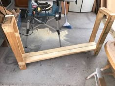 a table sawing on top of a wooden frame in a room with other woodworking tools