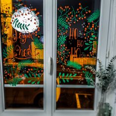 the window is decorated with orange and green leaves, which says happy ho ho ho