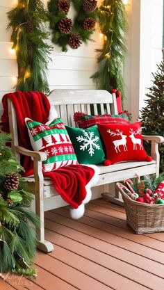 a white bench with christmas decorations on the back and red and green pillows sitting on top of it