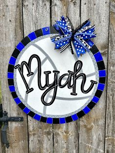 a blue and white sign with the word nyep on it hanging from a wooden fence