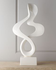 a white sculpture sitting on top of a wooden table