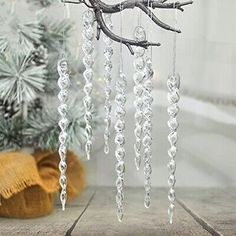 a branch with beads hanging from it next to a christmas tree