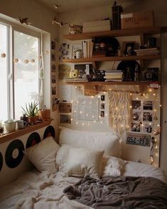 a bedroom with lots of lights and pictures on the wall above the bed, along with bookshelves