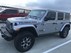 a silver jeep parked in a parking lot