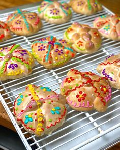 there are many decorated cookies on the cooling rack