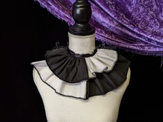 a mannequin with black and white ruffled collar