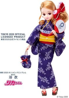 the doll is wearing a purple kimono and carrying a red purse with white flowers on it