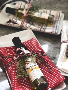 a bottle of olive oil sitting on top of a red and white napkin