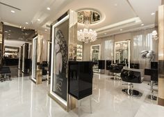 the interior of a hair salon with chandeliers and mirrors on the walls,