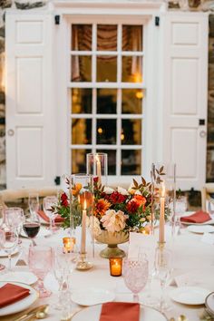 the table is set with candles, plates and napkins for an elegant wedding reception