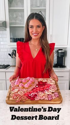 a woman standing in front of a tray of cookies