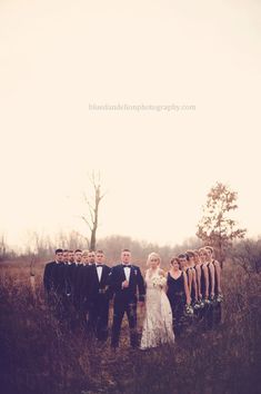 a bride and groom with their bridal party in a field at the same time