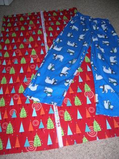 two baby pants laying on the floor next to each other with christmas trees and dogs on them